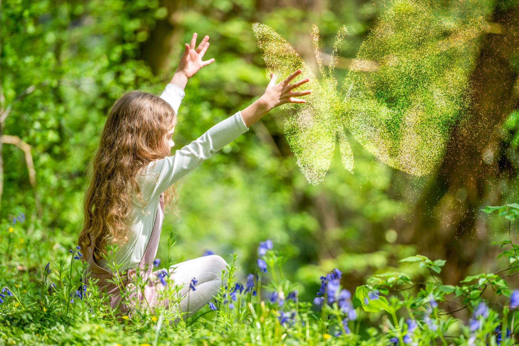 Child reaching towards sparkling light in a woodland scene