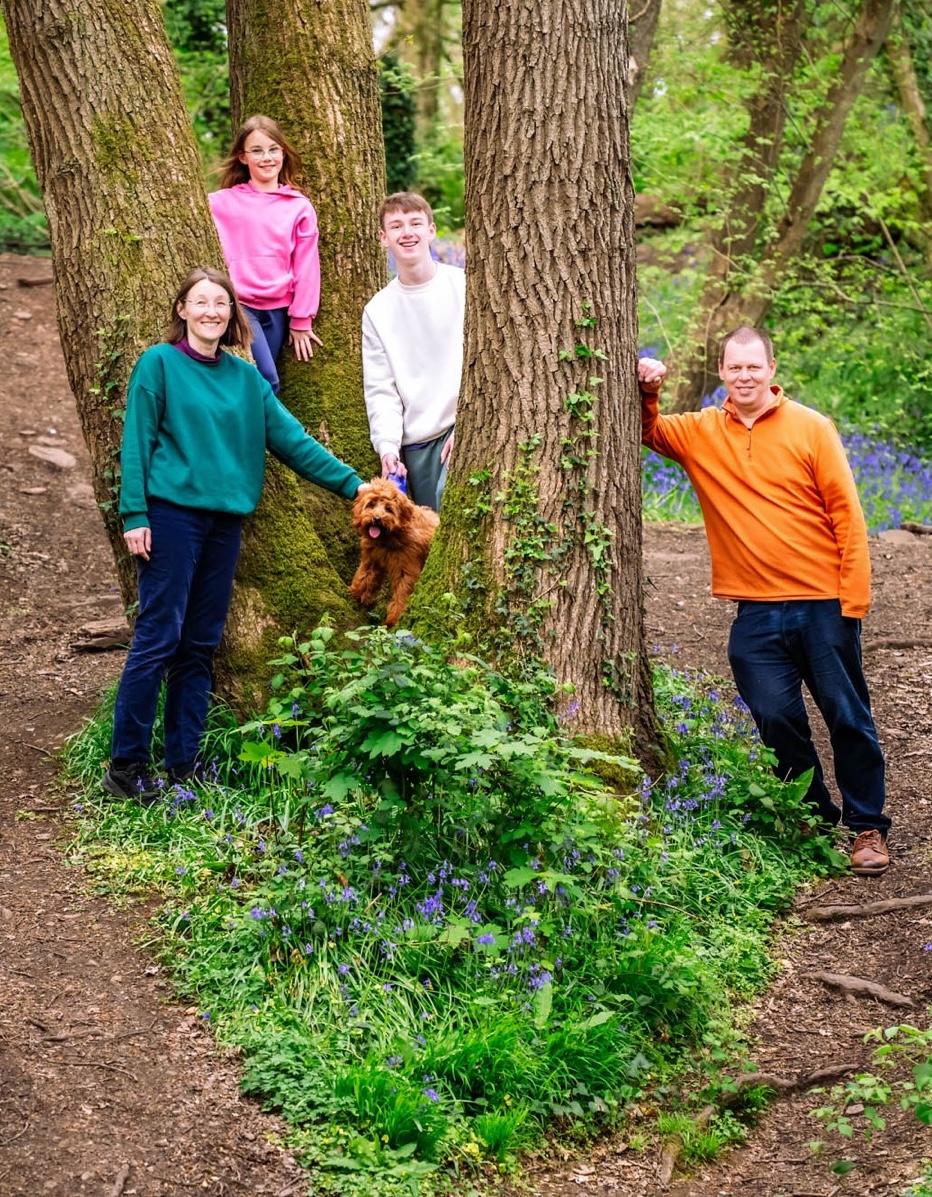 Family photographed with their dog in woodland