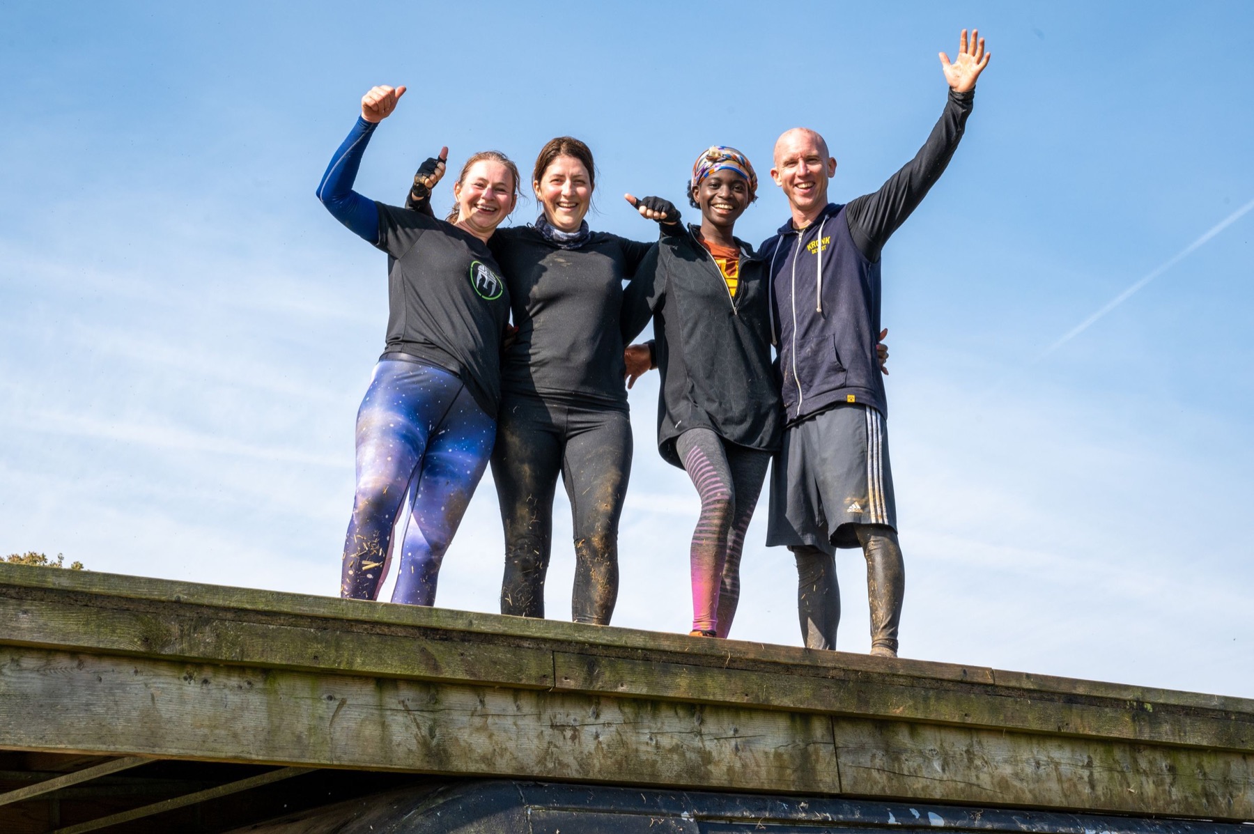 People celebrating after a muddy outdoor race