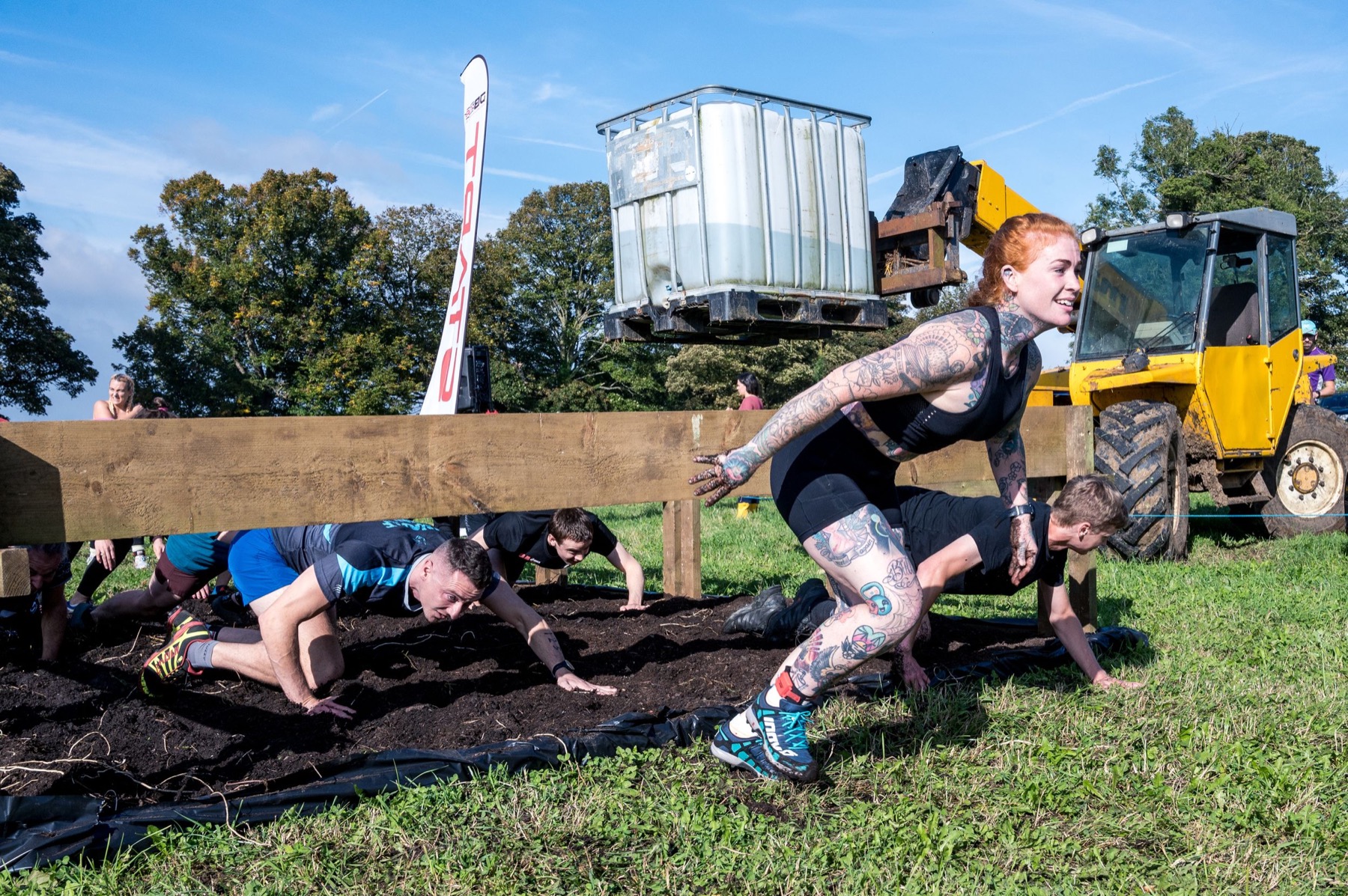 Muddy obstacle course runners smiling after a challenge